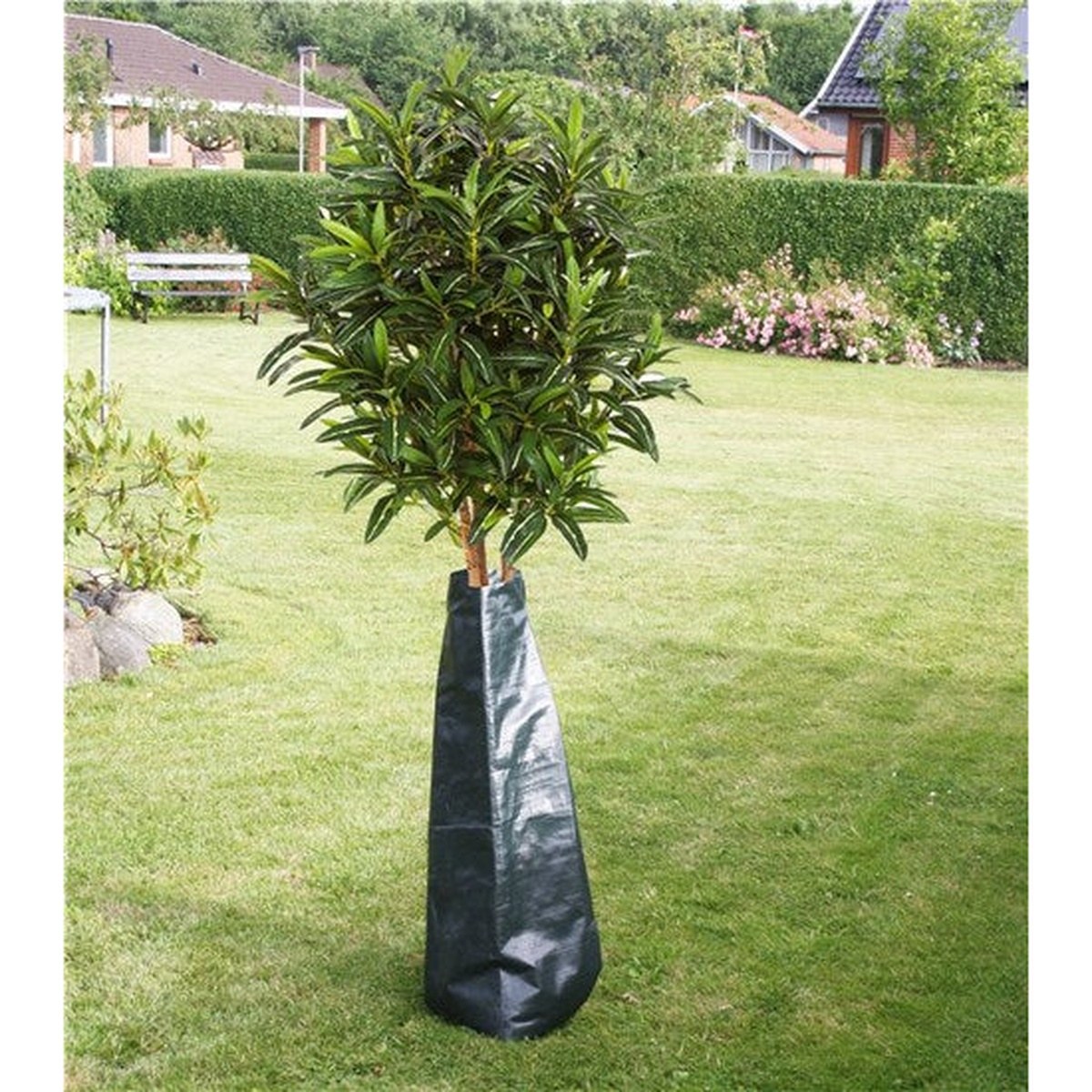 Grøn vandingspose rundt om træ i have, 75 liter vandingspose PE.